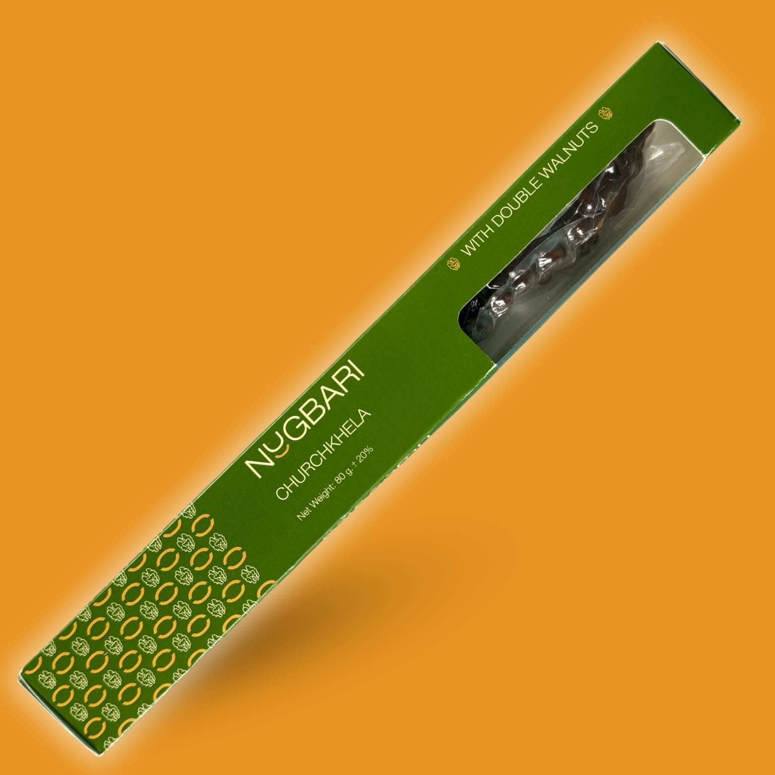 Large green box of Nugbari Churchkhela with double walnuts, handmade Georgian sweet made from natural grape juice and walnuts, healthy no-sugar snack.