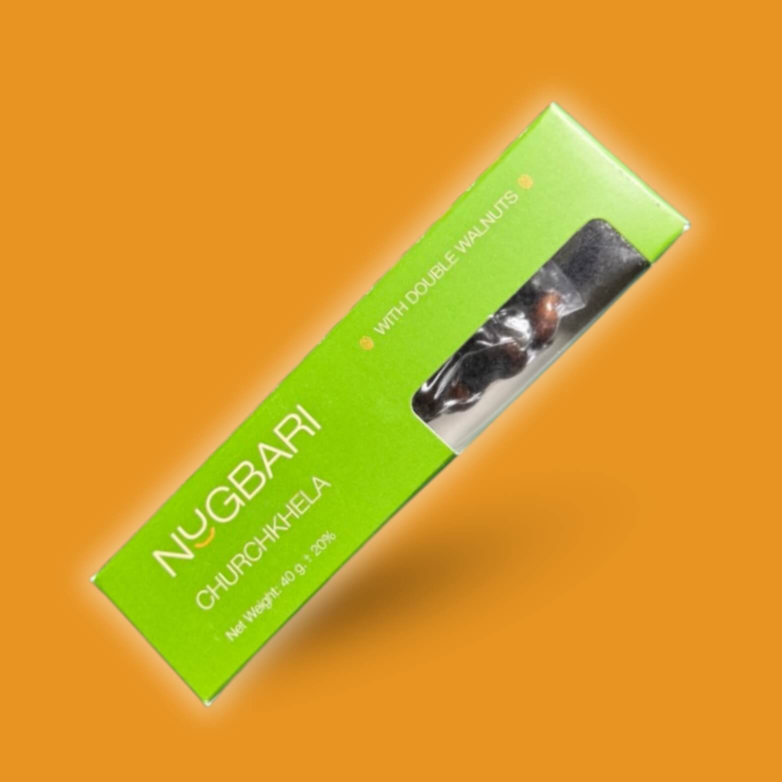 Small green box of Nugbari Churchkhela with double walnuts, traditional Georgian sweet made with natural grape juice and nuts, healthy energy snack.