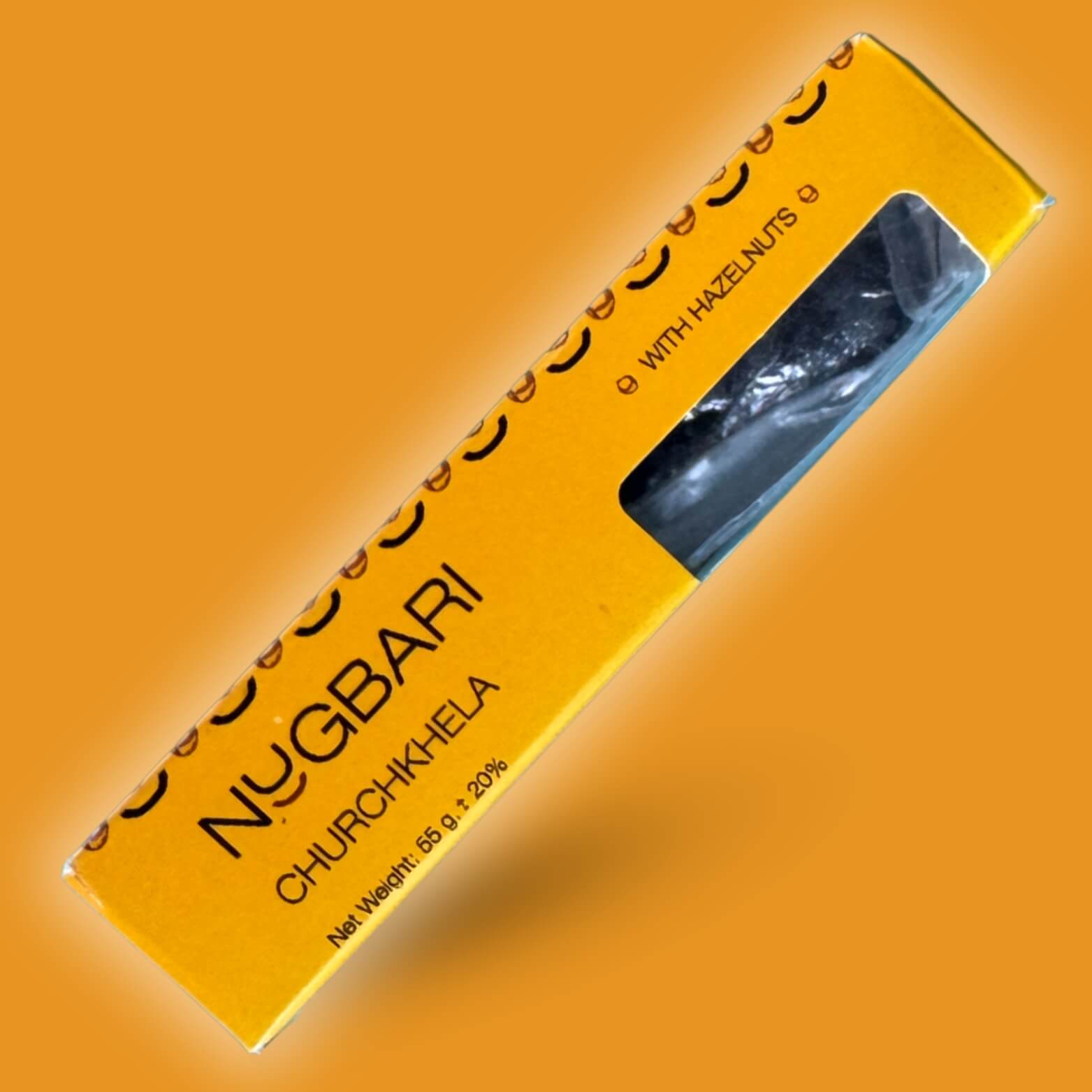 Small yellow box of Nugbari Churchkhela with hazelnuts, traditional Georgian sweet made from natural grape juice and crunchy nuts, healthy snack.